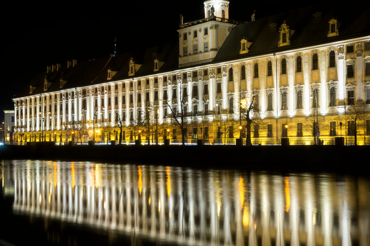 Mastering the First Impression: Your intriguing post title goes here Stunning night view of the illuminated University of Wrocław reflecting on the Odra River.
